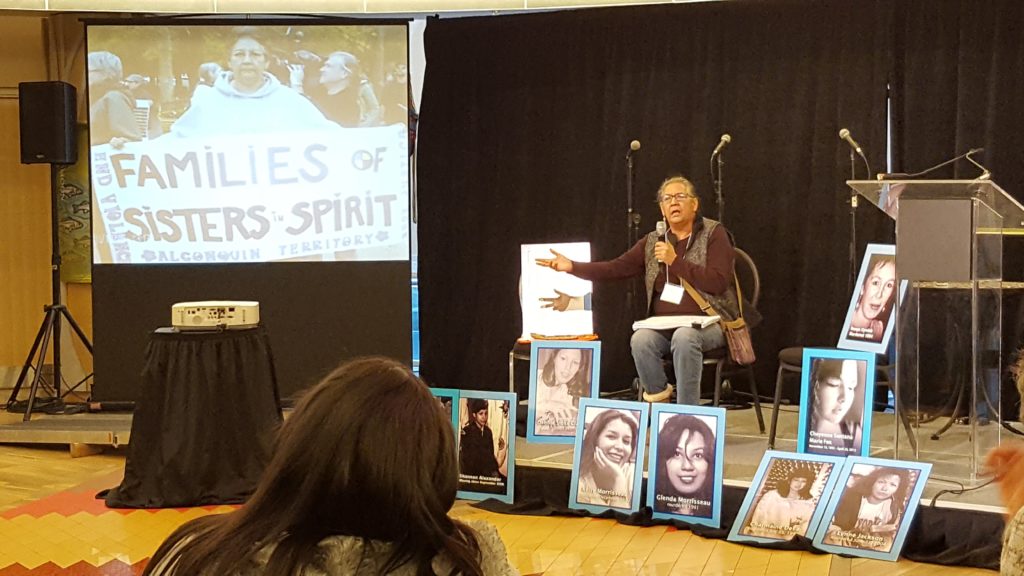 Bridget sits among posters of missing and murdered indigenous women.