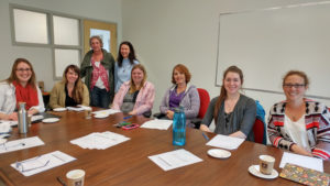 Group of women sitting at boardroom table and smiling